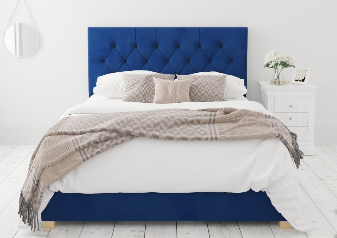 Sweet Dreams - 2020 Bedroom Interior Trend Predictions by Fashion Du Jour LDN. Close-up of a navy tufted upholstered headrest, pillows and white flowers in a white and grey bedroom interior