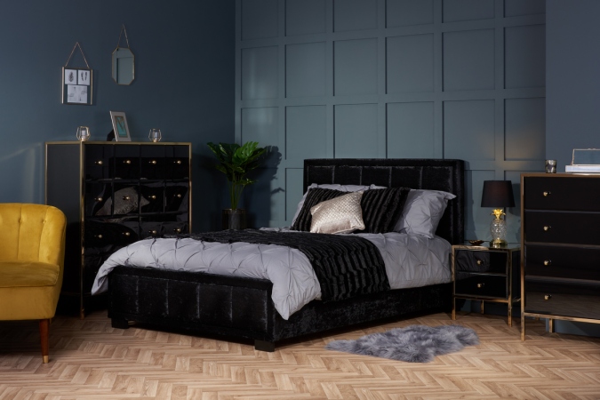 Sweet Dreams - 2020 Bedroom Interiors Trend Predictions by Fashion Du Jour LDN. Close-up of a black velvet bed, grey paneling on the walls,black and chrome gloss furniture, pillows and glass lamps in a grey bedroom interior