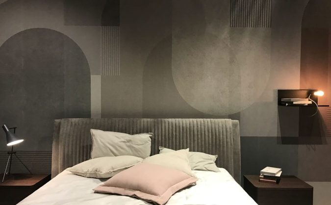 Sweet Dreams: Our 2020 Bedroom Interior Trend Predictions by Fashion Du Jour LDN. Close-up of a grey abstract geometric wallpaper and a grey velvet upholstered bed frame, pillows in a grey and blush pink bedroom interior