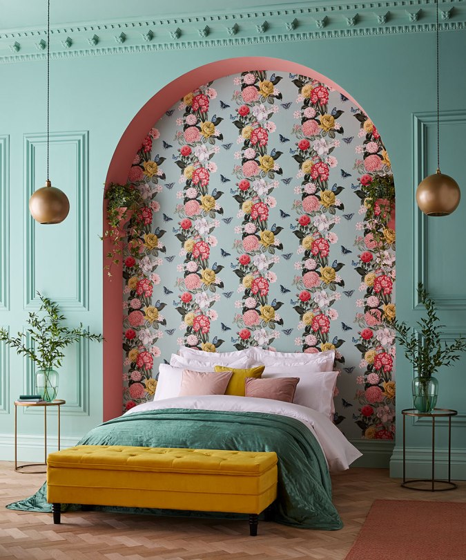 Sweet Dreams: Our 2020 Bedroom Interior Trend Predictions by Fashion Du Jour LDN. Close-up of bright floral Graham and Brown wallpaper, mint green wall paneling, mustard velvet ottoman, mint green, coral and mustard bedroom interior